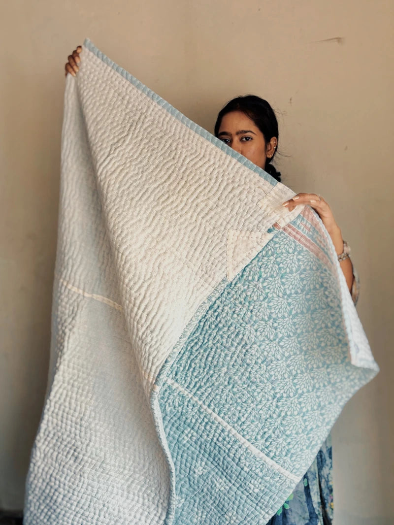 Padded kantha quilt with subtle pattern of traditional sari cloth through sheer white overlay