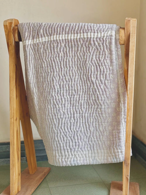 Padded kantha quilt with subtle pattern of traditional sari cloth through sheer white overlay