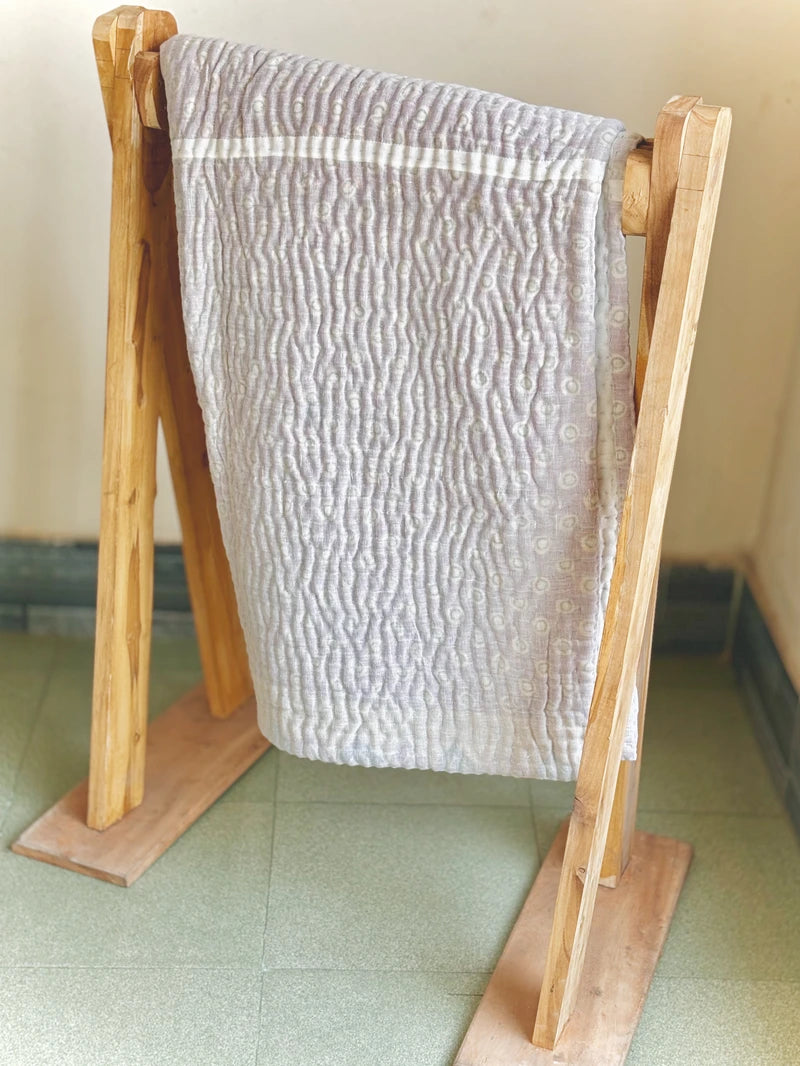 Padded kantha quilt with subtle pattern of traditional sari cloth through sheer white overlay