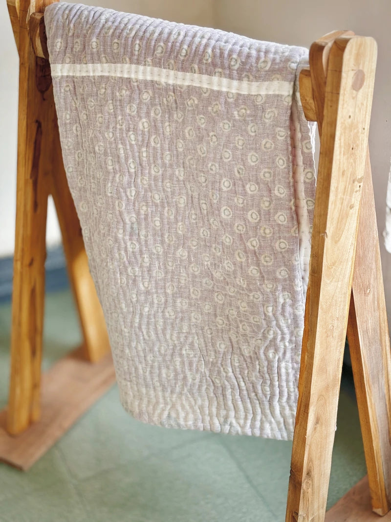 Padded kantha quilt with subtle pattern of traditional sari cloth through sheer white overlay