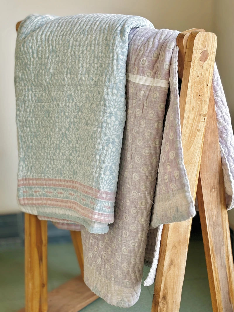 Padded kantha quilt with subtle pattern of traditional sari cloth through sheer white overlay