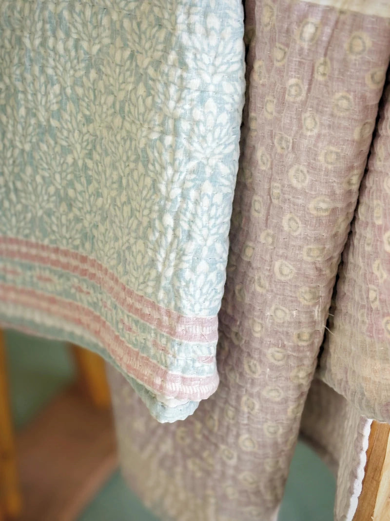 Padded kantha quilt with subtle pattern of traditional sari cloth through sheer white overlay