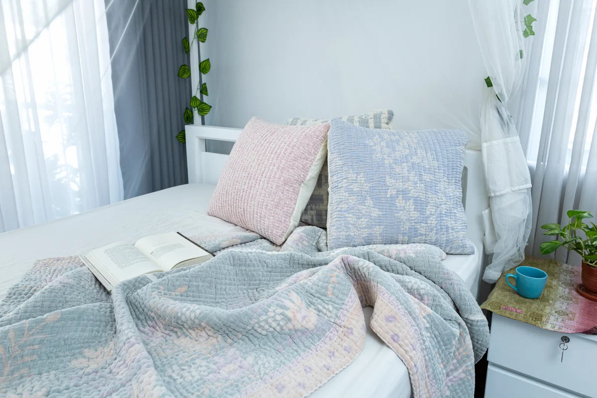 Padded kantha quilt with subtle pattern of traditional sari cloth through sheer white overlay