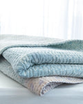 Padded kantha quilt with subtle pattern of traditional sari cloth through sheer white overlay