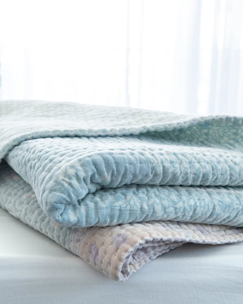 Padded kantha quilt with subtle pattern of traditional sari cloth through sheer white overlay